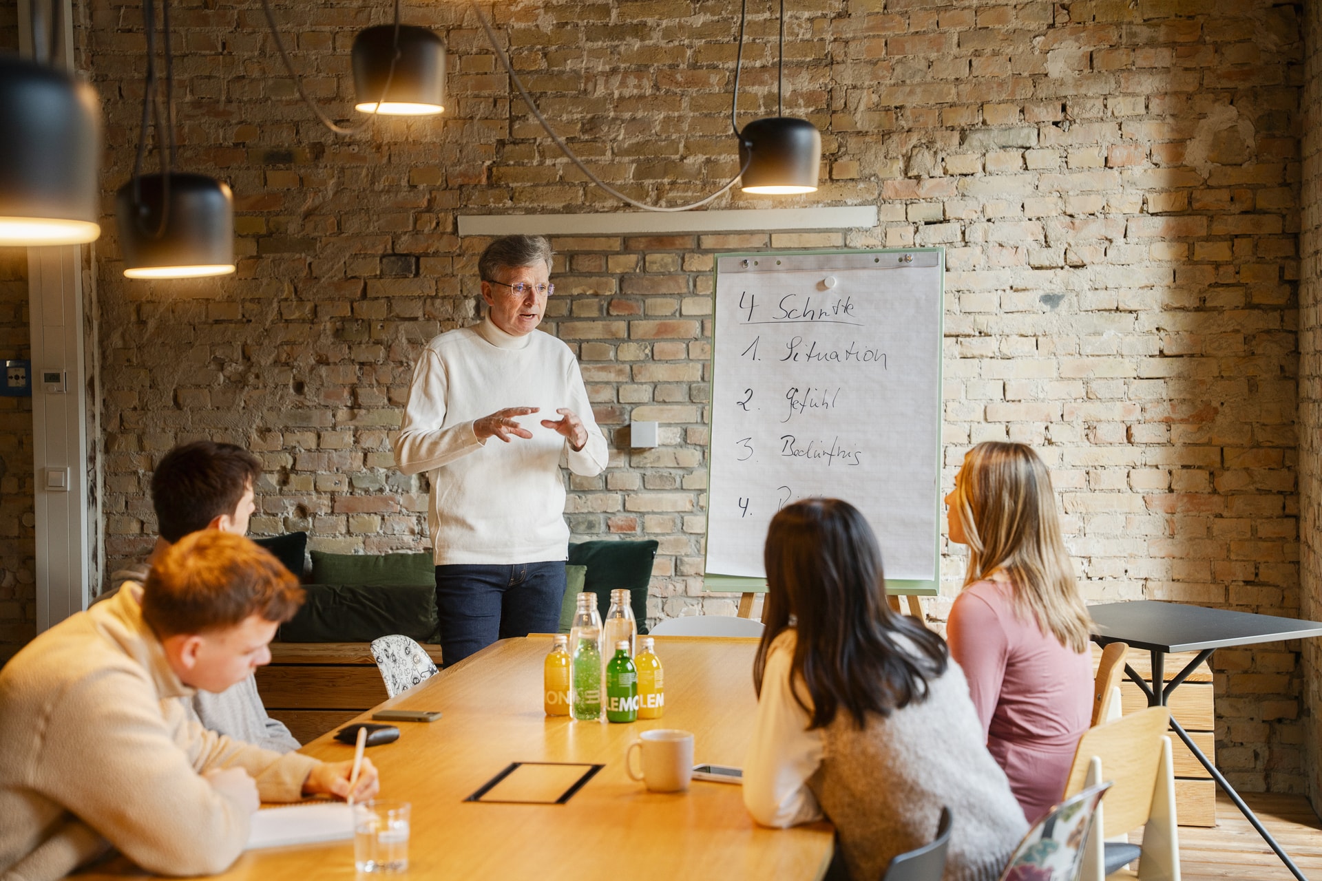Impression aus einem Seminar für Gewaltfreie Kommunikation für ein Unternehmen. GFK-Trainer Harald Bischoff mit Flipchart und Teilnehmenden